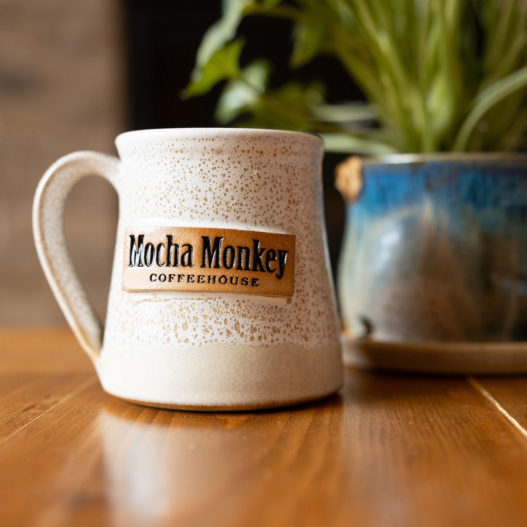 A handmade white and brown speckled Mocha Monkey Coffeehouse mug