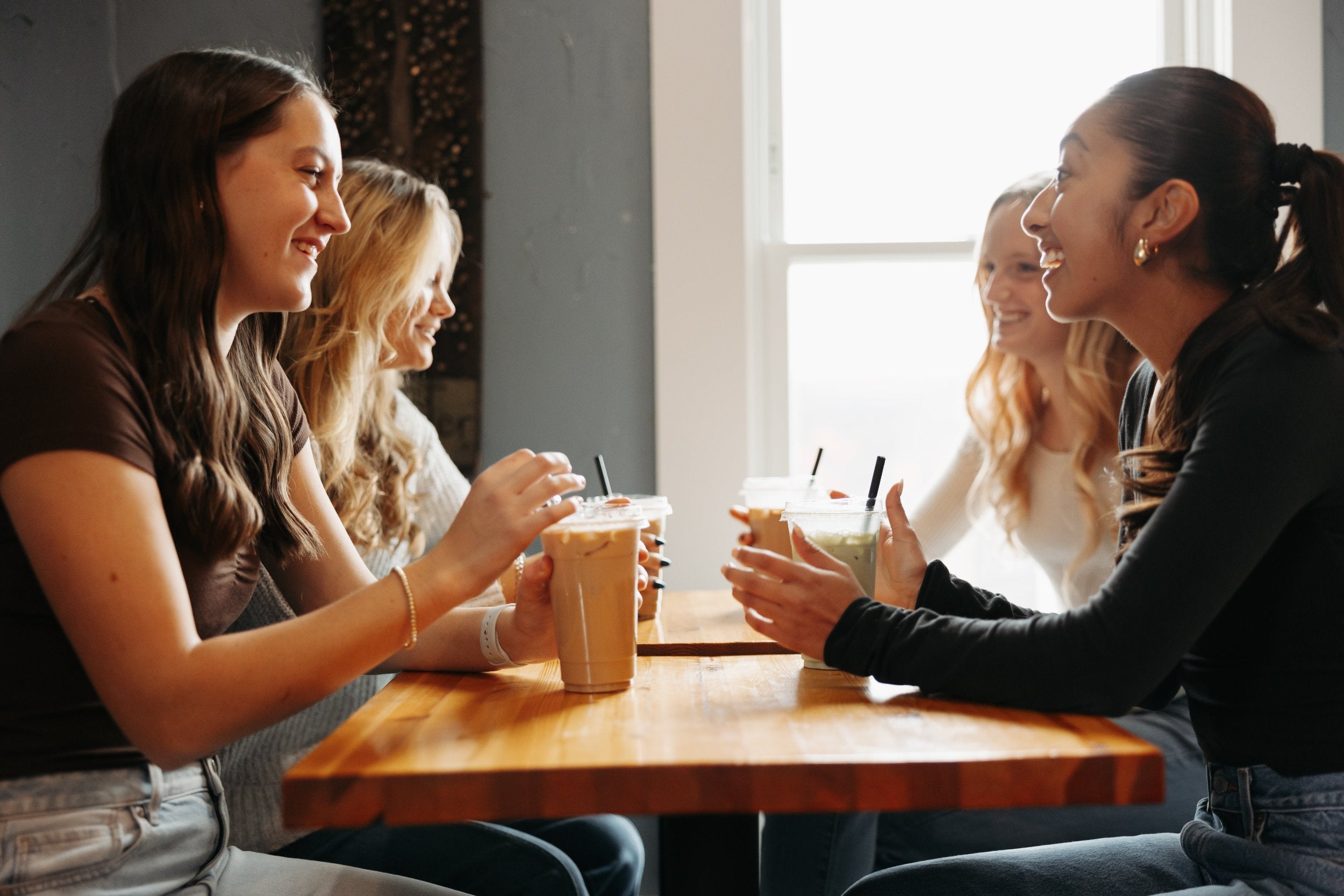 Four young women enjoying their Mocha Monkey specialty drinks