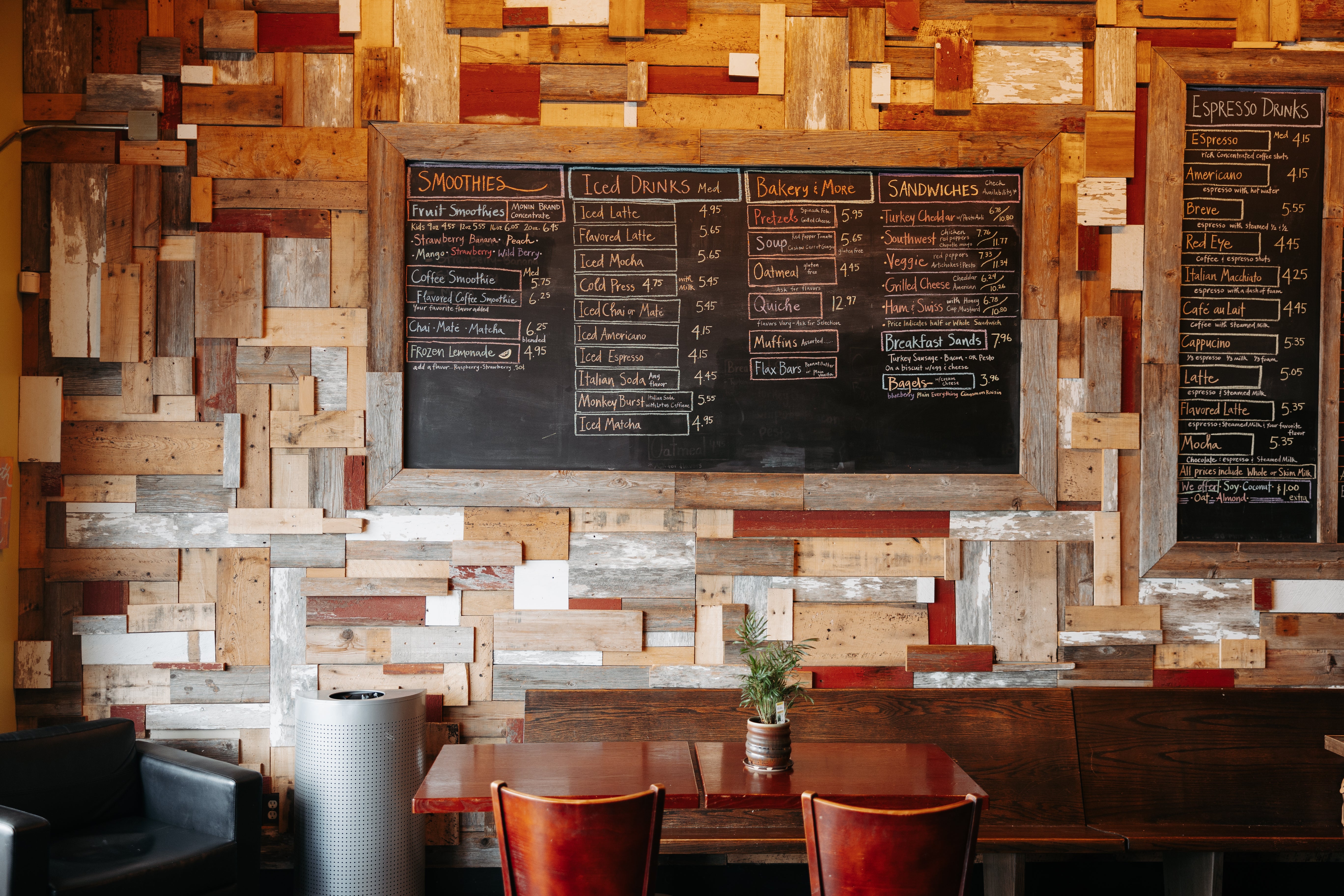 Chalkboard menus on a barn board wood wall with cafe seating in the foreground