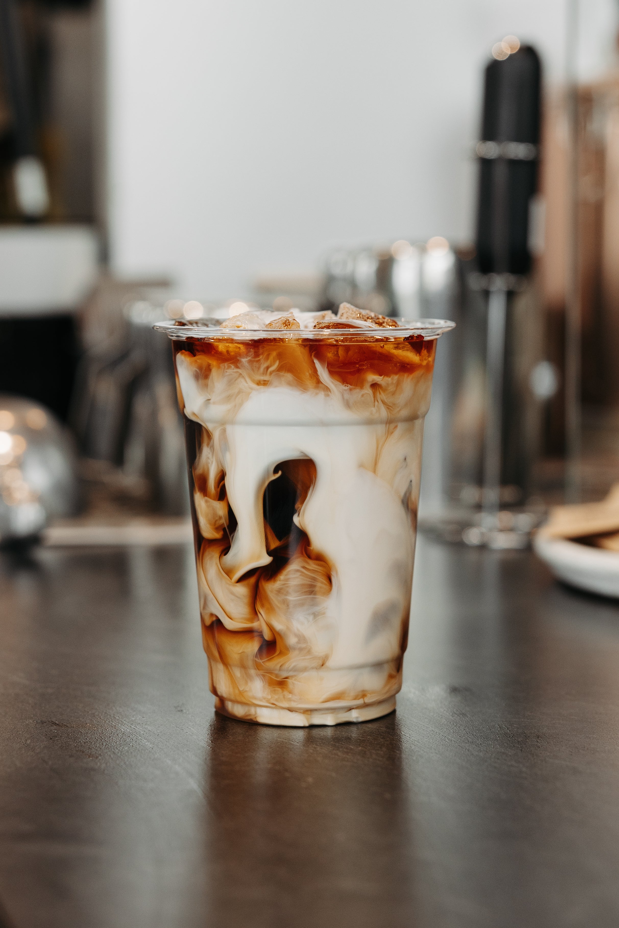 Beautiful, swirly, iced coffee drink in a see thru cup on a countertop