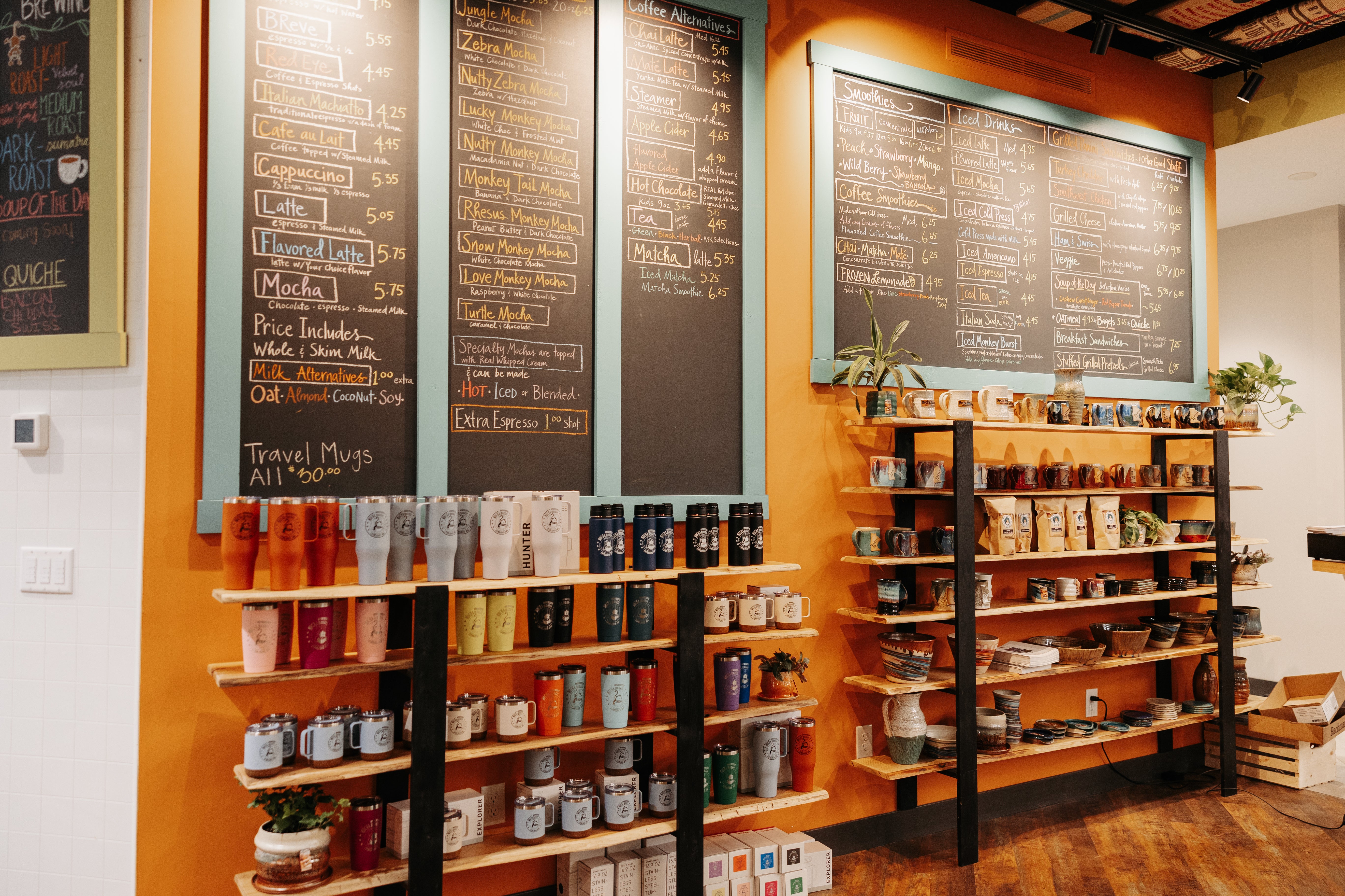 Pottery and Mocha Monkey merch under chalkboard menus at the Mocha Monkey Carver Coffeehouse